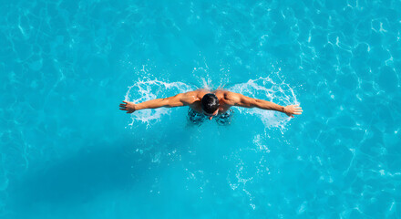 Aerial Top-Down View of Man Swimming Butterfly Stroke in Pool