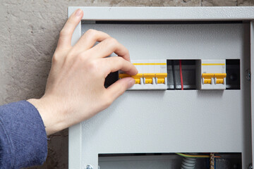 An electrician is installing wires on an electric meter