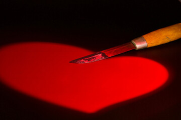 Ein rotes Herz mit einem Messer.