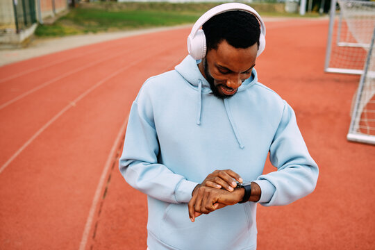 Man checking smartwatch data during track workout