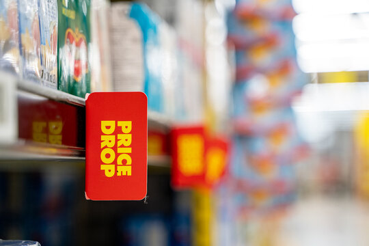 Close up of price drop sign on supermarket shelf.