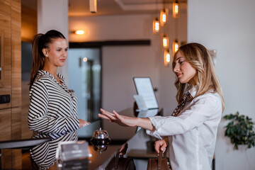 Receptionist assists hotel guest during check-in process in modern lobby setting
