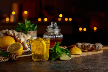 Cup of ginger tea with lemon, honey, mint, and ginger root.