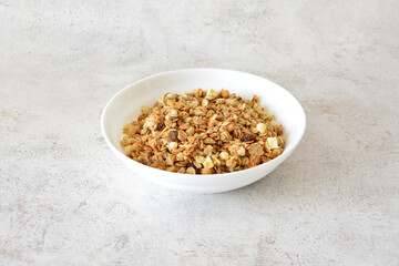 Granola in a white bowl cut out on gray background