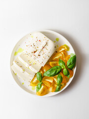 feta cheese with yellow tomatoes and basil