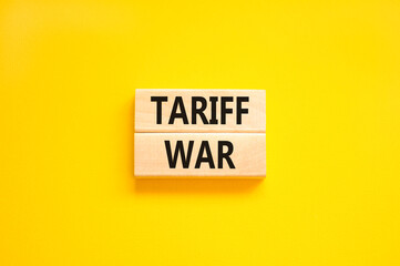Trade tariff war symbol. Concept word Tariff war on beautiful wooden blocks. Beautiful yellow paper background. Business trade tariff wars concept. Copy space.