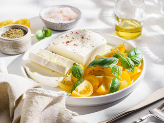 feta cheese with yellow tomatoes and basil