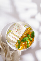 feta cheese with yellow tomatoes and basil