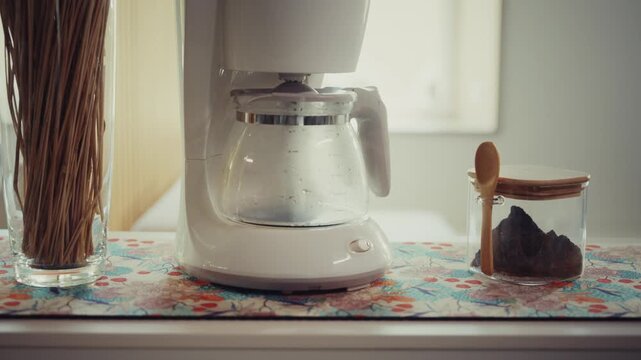Coffee Maker and Jar with Spoon on Kitchen Counter