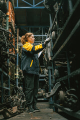 Technician adult women worker working in heavy industry, warehouse manager in garage scrap yard