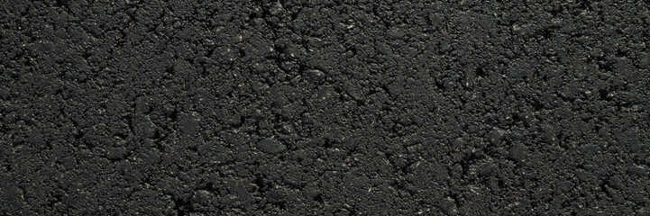 New dark black asphalt background. Closeup. Wide banner. Empty place for text. Top down view.