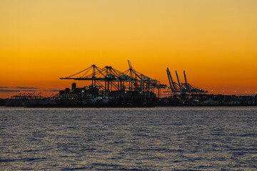 Obraz premium Container terminal with cranes in Hudson Bay at sunset.