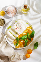 feta cheese with yellow tomatoes and basil