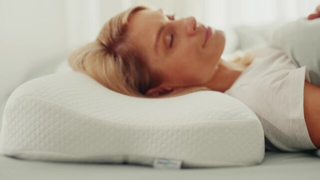 Close-up of a relaxed woman sleeping on her back on a contoured memory foam orthopedic pillow