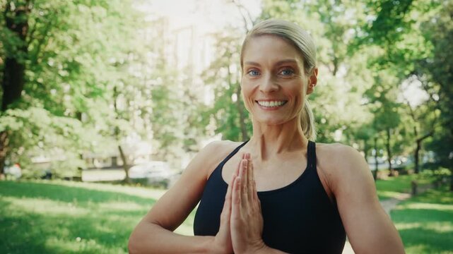 Smiling fit woman doing yoga pose outdoors in park