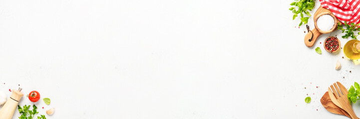 Spices, herbs and vegetables with olive oil on white kitchen table.