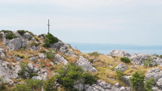 Ancient stone chapel on a coastal mountain ridge with panoramic sea view of the Dalmatian coast.