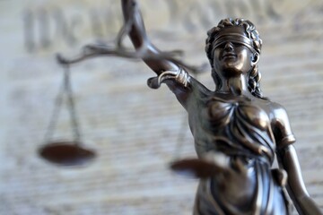 The statue of justice Themis or Justitia, the blindfolded goddess of justice against US Constitution