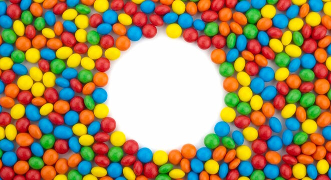 Colorful sugar and color coated chocolate candy frame with circle copy space, white background