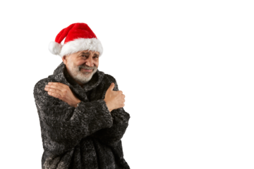 A portrait of a senior citizen wearing a fur coat and Santa Claus hat, his face miserable from the cold. He tries to keep warm by hugging himself. Png .