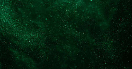 Blur particles. Glitter texture. Natural green color illuminated glare shimmer art floating on abstract bokeh dark black background.