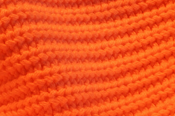 A close up of a knitted orange sweater