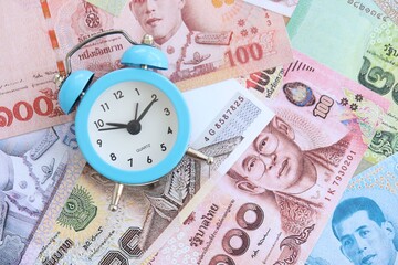 Thai baht currency money bills and alarm clock. The concept of time management and income