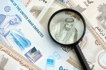United Arab Emirates dirham currency money bills and magnifying glass. The concept of financial monitoring and taxation