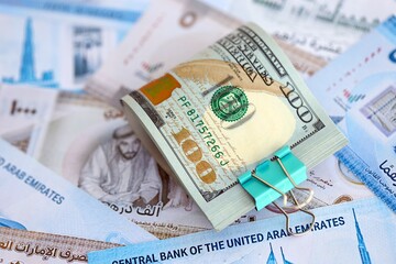 United Arab Emirates dirham currency money bills and bunch of us dollar banknotes. The concept of economics and currency exchange