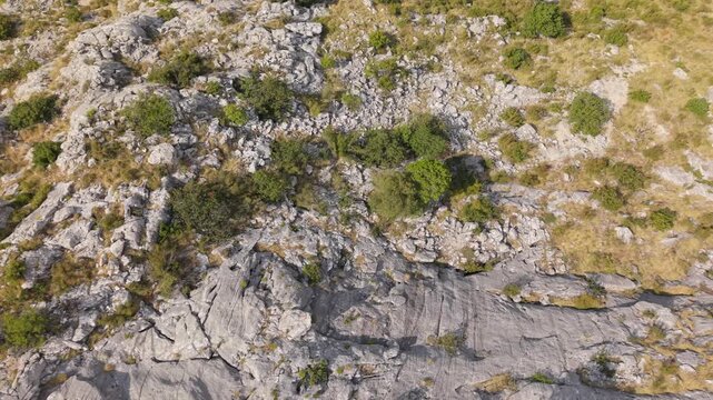 Ancient stone chapel on a coastal mountain ridge with panoramic sea view of the Dalmatian coast.