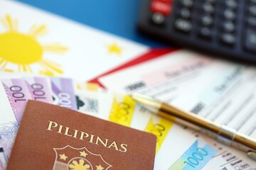 Philippines peso money bills and calculator with tax form on flag. Taxation and accounting concept