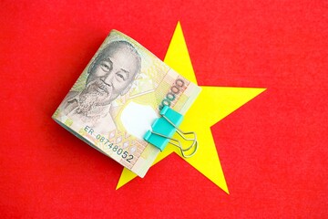 Vietnamese dong currency money bills lies on flag. The concept of business and investment
