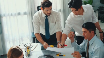 Top view of engineer pointing at turbine engine at meeting table with equipment. Aerial view of professional project manager talking and discussing about electronic generator system. Alimentation.