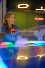 An emotional and exciting air hockey game. A girl holds a shoe to play with