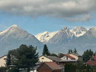 Majestic mountain peaks under cloudy sky. Scenic alpine landscape with snow-capped summits.