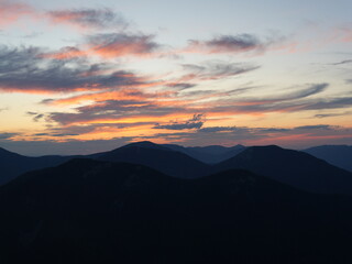 Peaceful night in the mountains — campfire, tents and starry sky