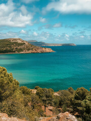 Fototapeta premium Scenic coastal view with turquoise waters and rugged cliffs under a blue sky.