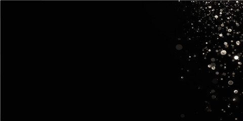 Water drops and splash in motion on a black background with a hint of bright light and smoke