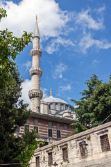 Blue Mosque (Sultan Ahmed Mosque) with minarets and domes under a bright blue sky with clouds in Istanbul, Turkey – iconic Ottoman architecture.