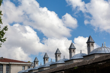Ottoman-style domes and chimneys of the Sultanahmet Foundation in Istanbul, Turkey, under a bright blue sky with beautiful white clouds, in Istanbul, Turkey. 