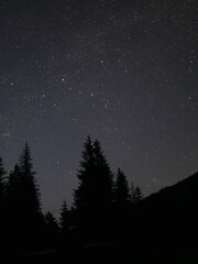 Fototapeta premium Peaceful night in the mountains — campfire, tents and starry sky