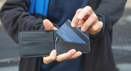 Caucasian man showing wallet with a credit card.