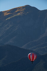 red and white balloon in front of Sandia Mountains