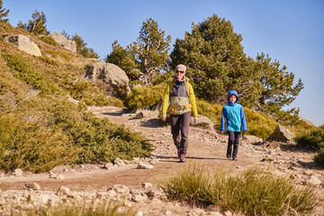 Naklejka premium Mother and son descending a mountain path