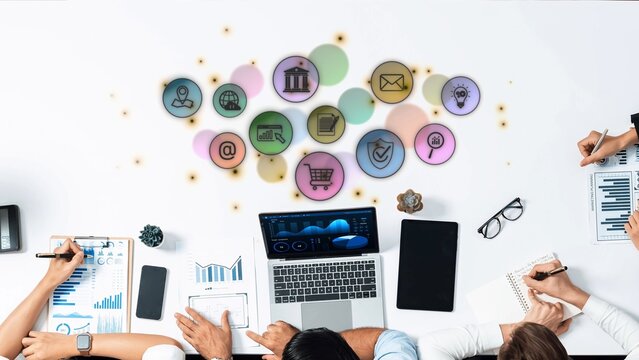 A diverse team collaborates on innovative digital marketing strategies with technology icons and charts visible, emphasizing teamwork and productivity in a modern workspace. Raster - Powered by Adobe