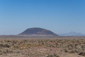 Naklejka premium Middle Butte is a cryptodome composed of basalt which formed when an underlying mass of rhyolitic magma pushed up overlying layers of basalt of the Snake River Plain. Bingham County, Idaho