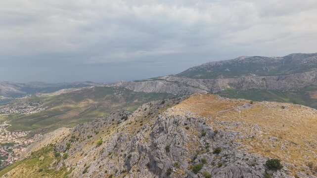 Ancient stone chapel on a coastal mountain ridge with panoramic sea view of the Dalmatian coast.