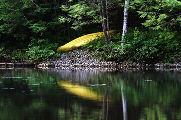 canoe reflecting on the water inviting a new adventure of sport and relaxation