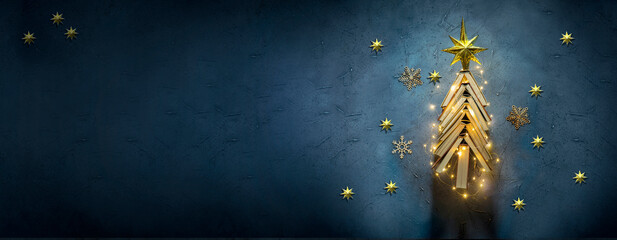 Vintage books arranged in a Christmas Tree shape on a dark blue background with copy space. New Year in the library concept. Literature for winter evenings during the holidays.