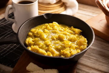 Scrambled eggs in green sauce in an cast iron skillet. A typical Mexican breakfast of scrambled eggs tossed in spicy green sauce, usually accompanied by beans and pot coffee.